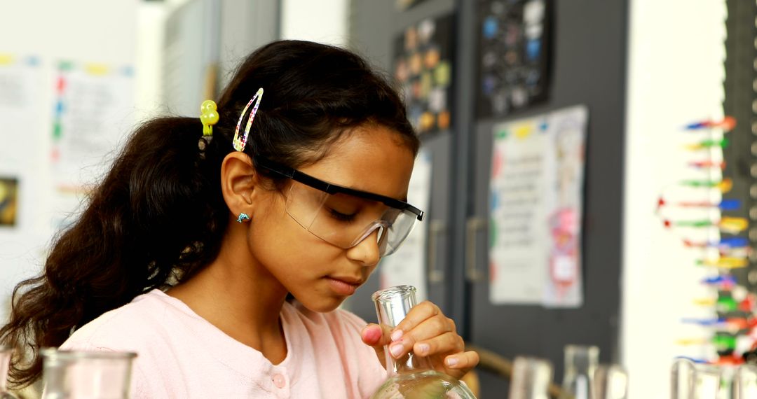 A young girl of diverse ethnicity is focused on conducting a science experiment, with copy space - Free Images, Stock Photos and Pictures on Pikwizard.com
