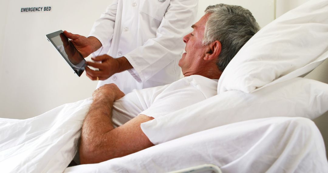 Doctor Showing Tablet to Senior Male Patient in Hospital Bed - Free Images, Stock Photos and Pictures on Pikwizard.com