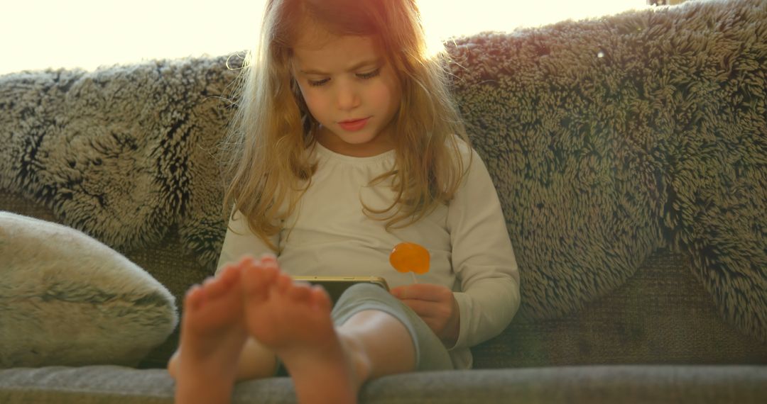 Young Girl Using Digital Tablet on Cozy Sofa in Morning Light - Free Images, Stock Photos and Pictures on Pikwizard.com