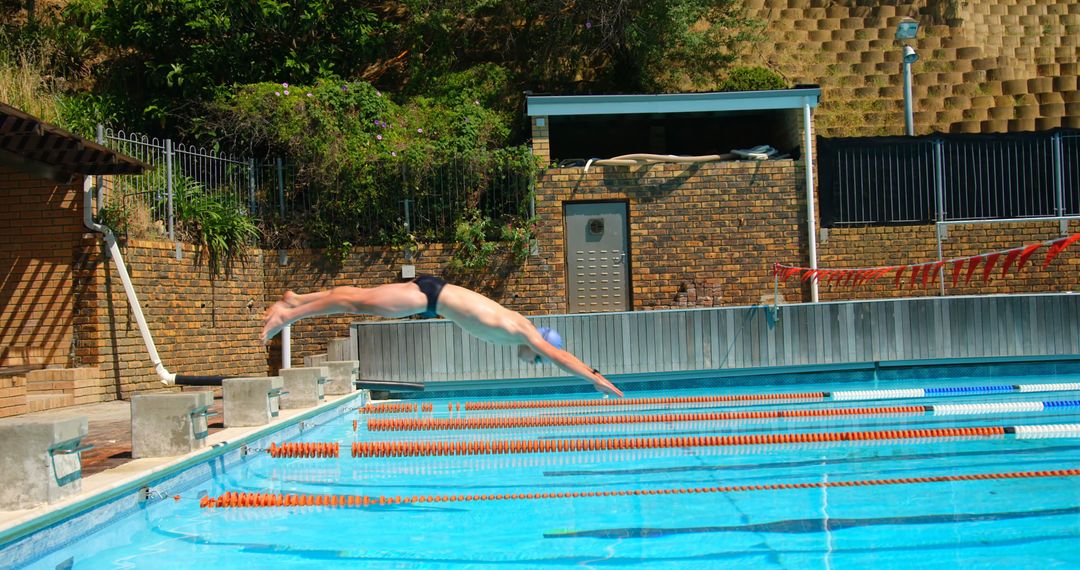 Man Diving into Outdoor Swimming Pool on Sunny Day - Free Images, Stock Photos and Pictures on Pikwizard.com