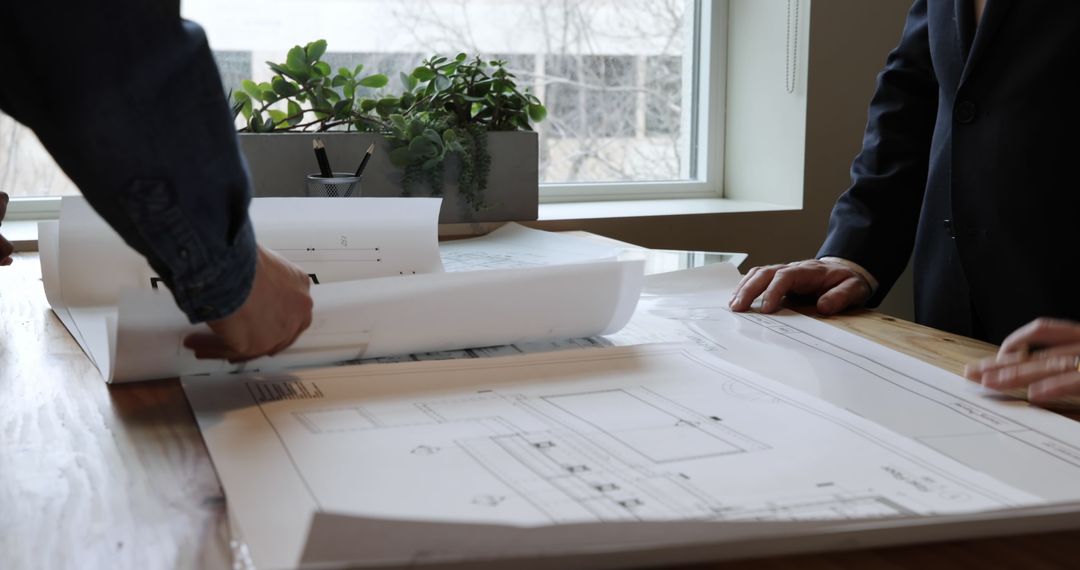 Architects Collaborating on Project Plans in Modern Office