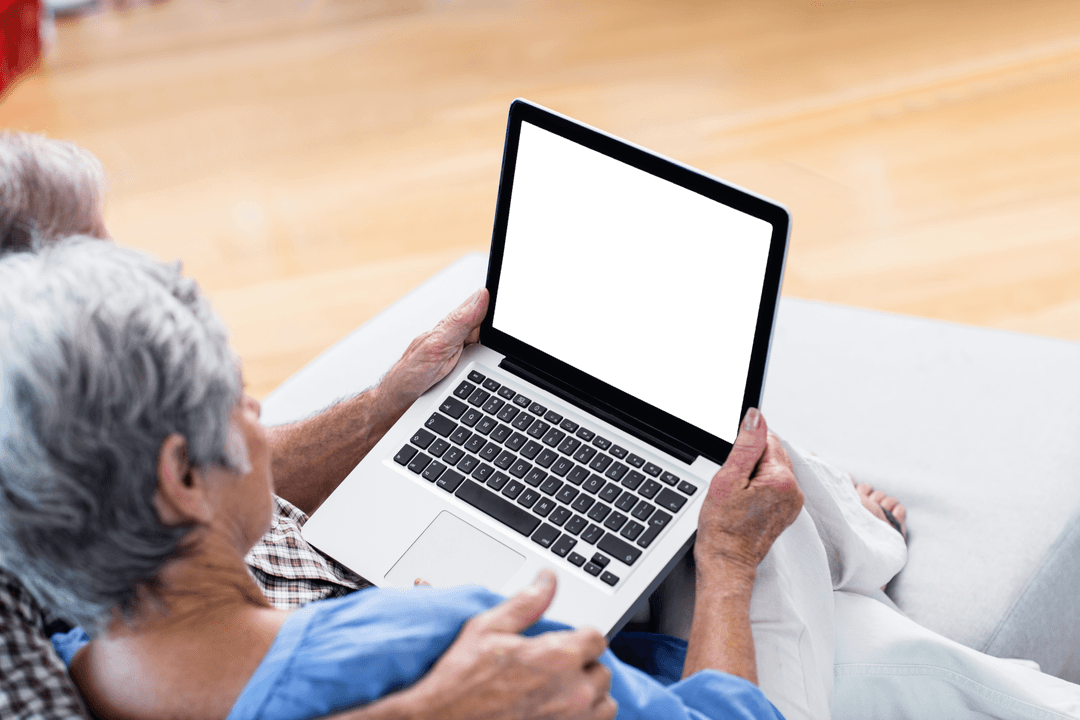 Senior Couple Using Laptop with Transparent Screen Indoors