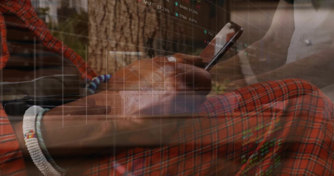 Holding smartphone scrolling on plaid cloth with beaded bracelet and market data overlay