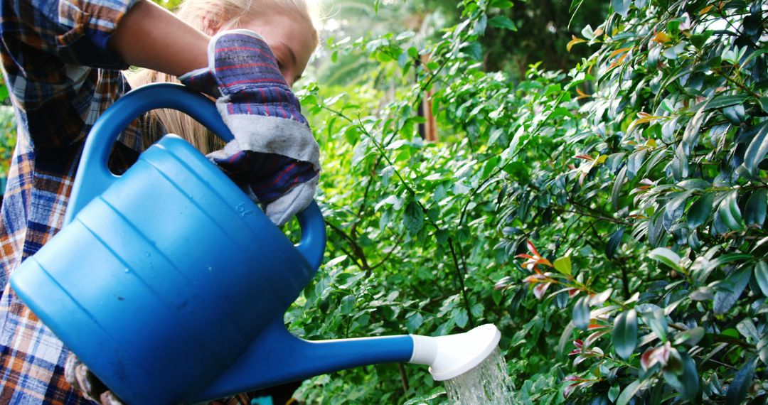 Young Girl Watering Plants with Blue Watering Can in Garden - Free Images, Stock Photos and Pictures on Pikwizard.com