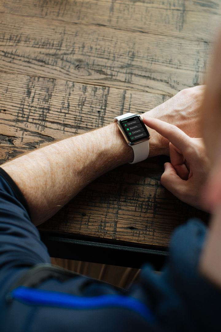 Person Using Smartwatch At Wooden Table - Free Images, Stock Photos and Pictures on Pikwizard.com