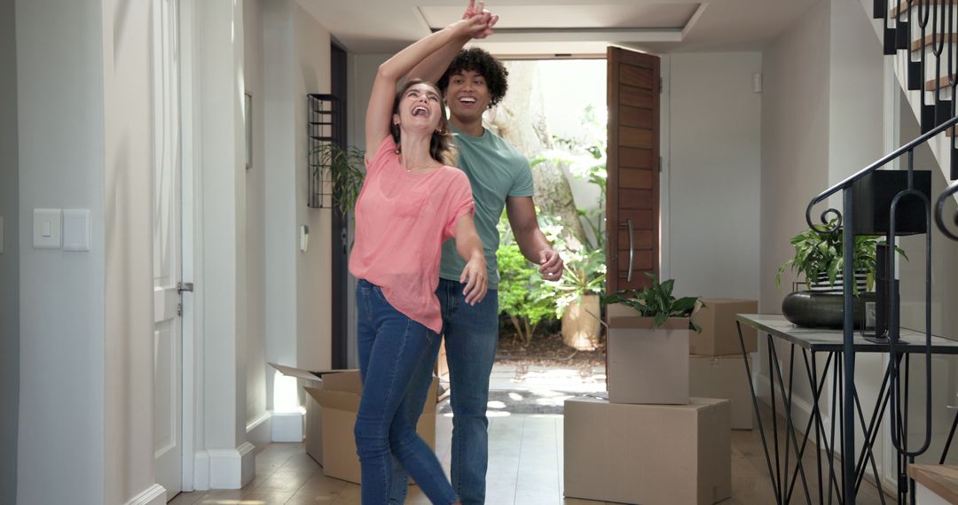 Young Couple Joyfully Entering New Home with Moving Boxes