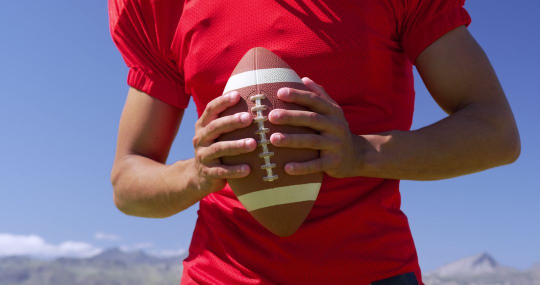 Football Player in Red Uniform Holding Ball Outdoors - Free Images, Stock Photos and Pictures on Pikwizard.com