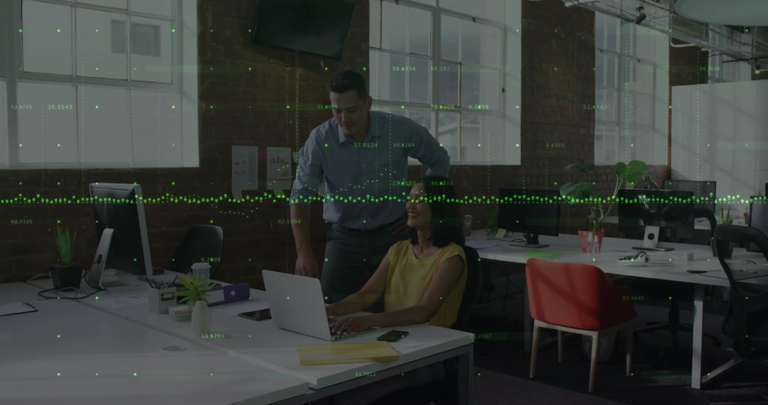 Business team collaborating over laptop in modern industrial office with data overlay