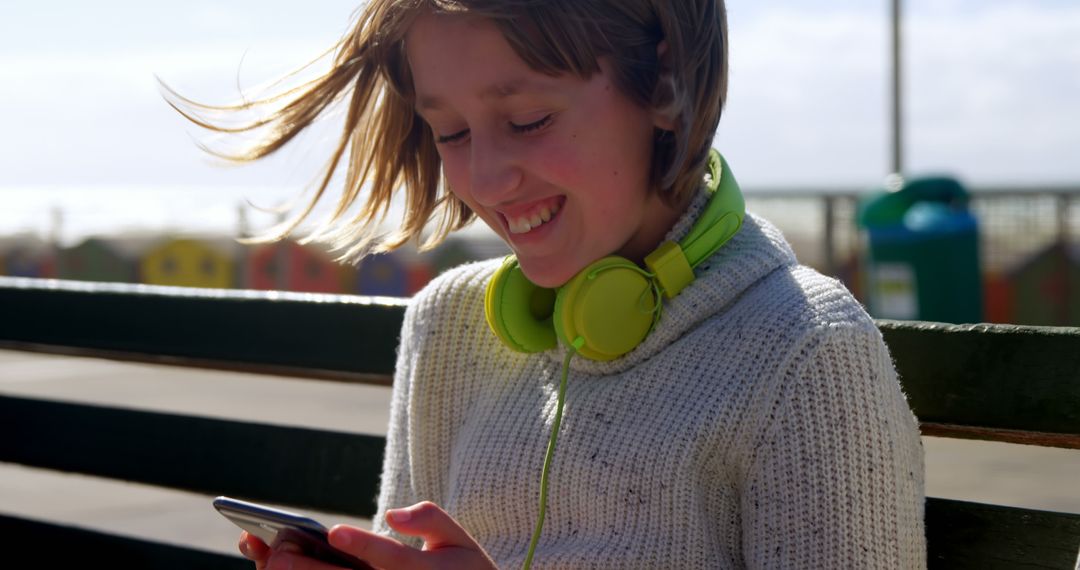 Cheerful Girl Enjoying Music and Smartphone at Beach - Free Images, Stock Photos and Pictures on Pikwizard.com