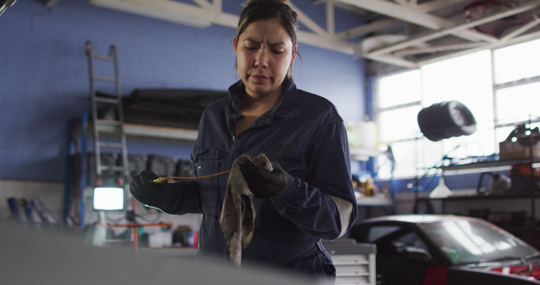 Female Mechanic Inspecting Car Engine Oil in Auto Repair Garage - Free Images, Stock Photos and Pictures on Pikwizard.com