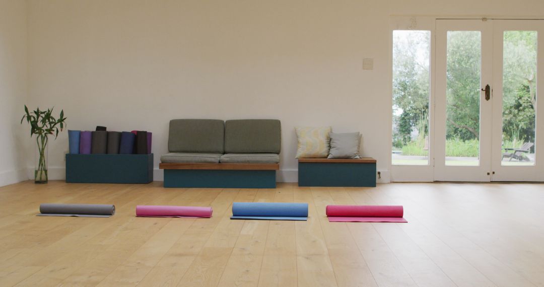 Serene Yoga Studio with Rolled Mats in Spacious Room