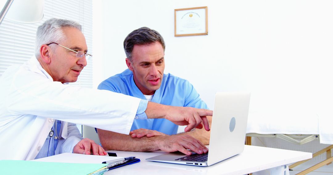 Two Doctors Discussing Medical Records on Laptop in Office - Free Images, Stock Photos and Pictures on Pikwizard.com