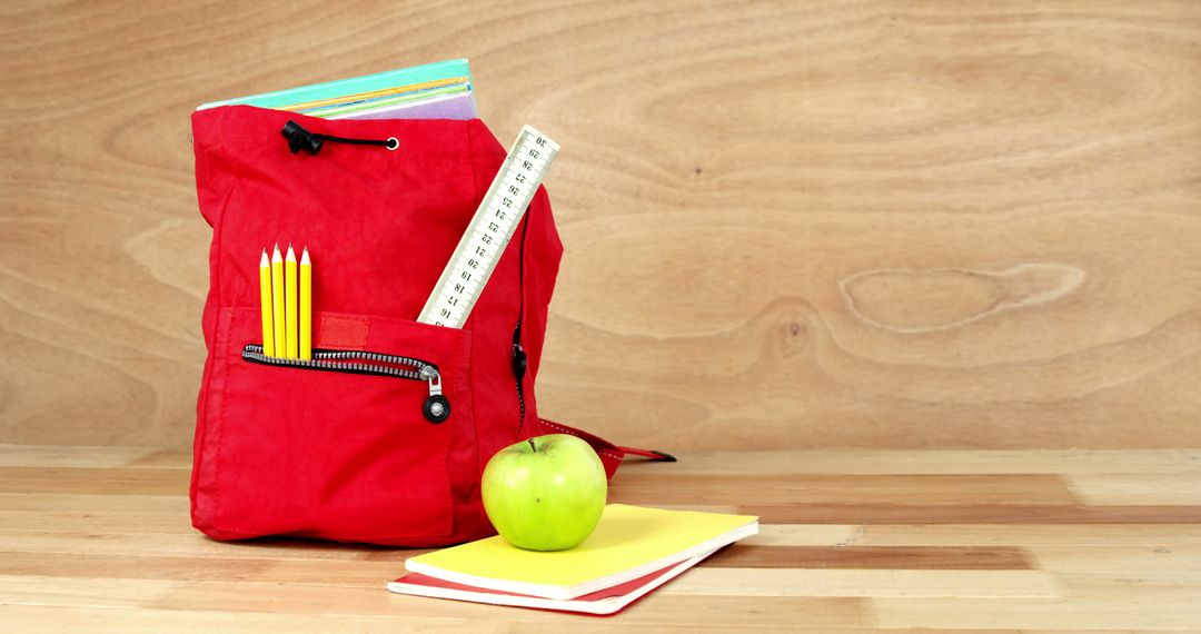 Red Backpack with School Supplies and Green Apple