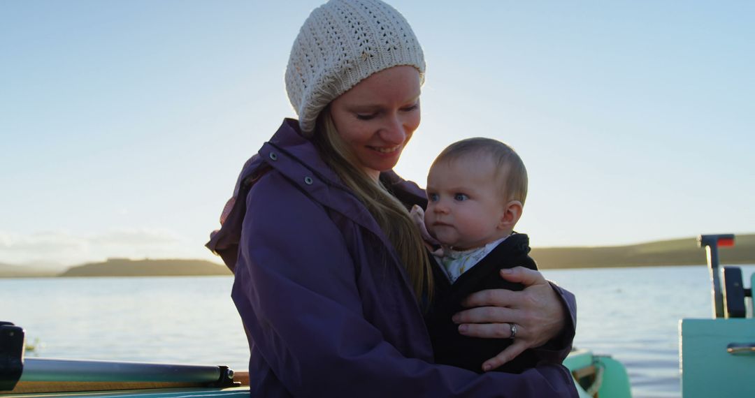 Mother Holding Baby Enjoying Calm Boat Ride at Sunset - Free Images, Stock Photos and Pictures on Pikwizard.com