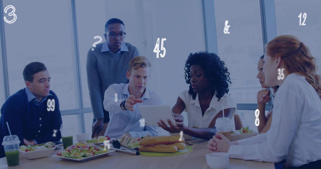 Team collaborating over tablet during working lunch in modern office with takeout food