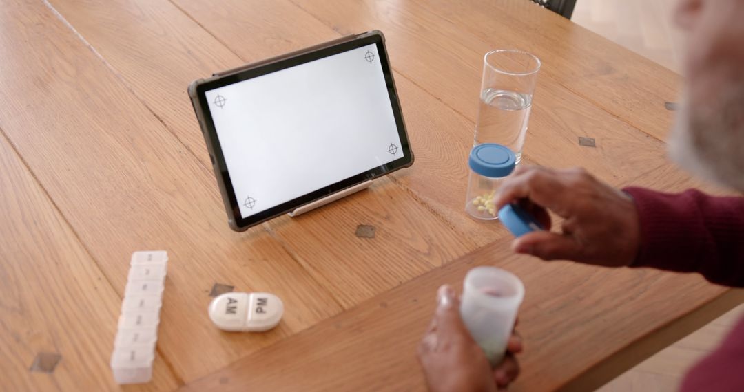 Elderly Person Preparing Medication with Digital Tablet Instruction - Free Images, Stock Photos and Pictures on Pikwizard.com