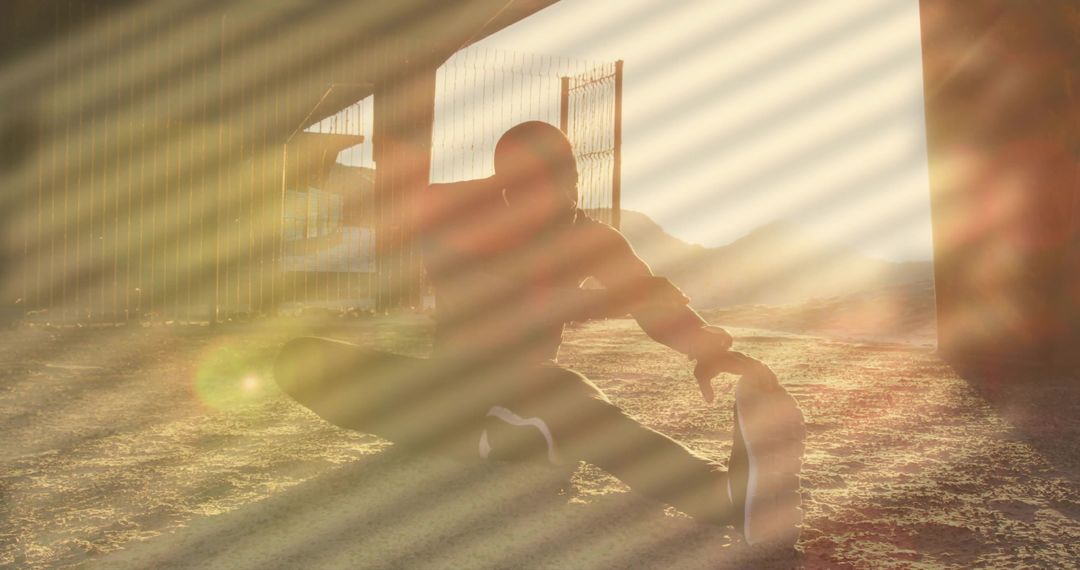 Backlit Urban Athlete Stretching under Overpass