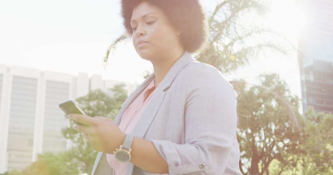Plus Size Biracial Woman Walking and Texting in City Street