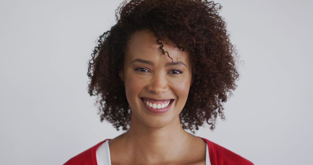 Smiling Woman with Curly Hair in Red Sweater - Free Images, Stock Photos and Pictures on Pikwizard.com