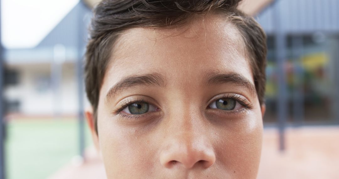 Close-Up Portrait of Young Student with Brown Eyes in Playground