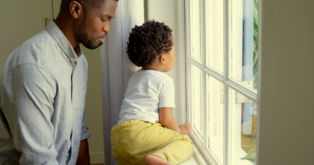 Father and Child Looking Out Window with Curiosity - Free Images, Stock Photos and Pictures on Pikwizard.com