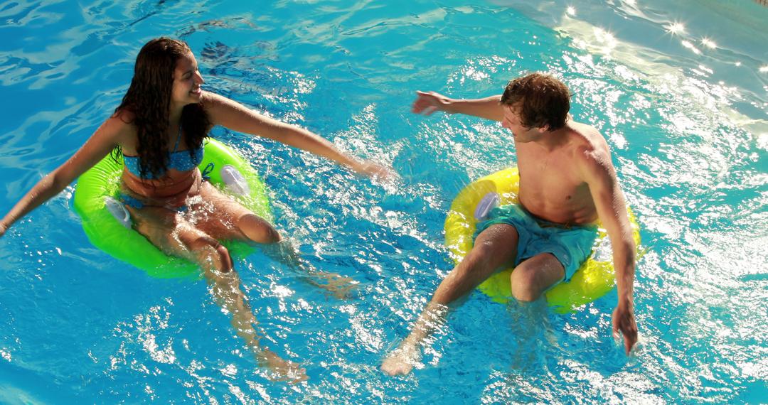 Joyful Couple Floating on Inflatable Rings in Pool - Free Images, Stock Photos and Pictures on Pikwizard.com