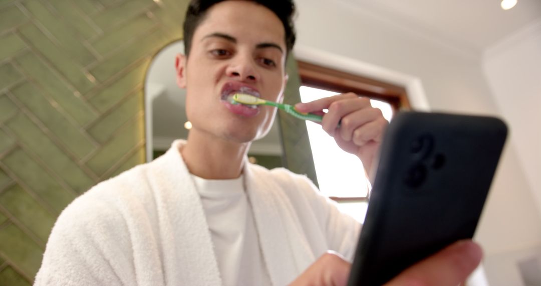 Man multitasking brushing teeth and using smartphone in bathroom