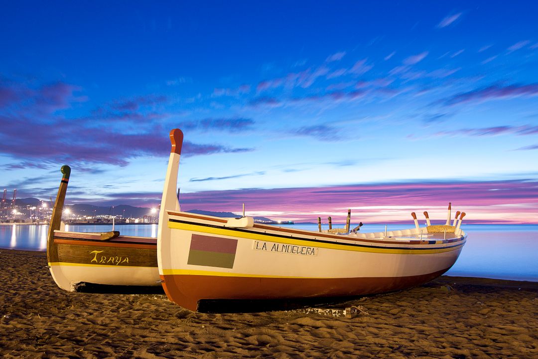 Colorful Boats on Beach during Sunset with Vibrant Sky - Free Images, Stock Photos and Pictures on Pikwizard.com