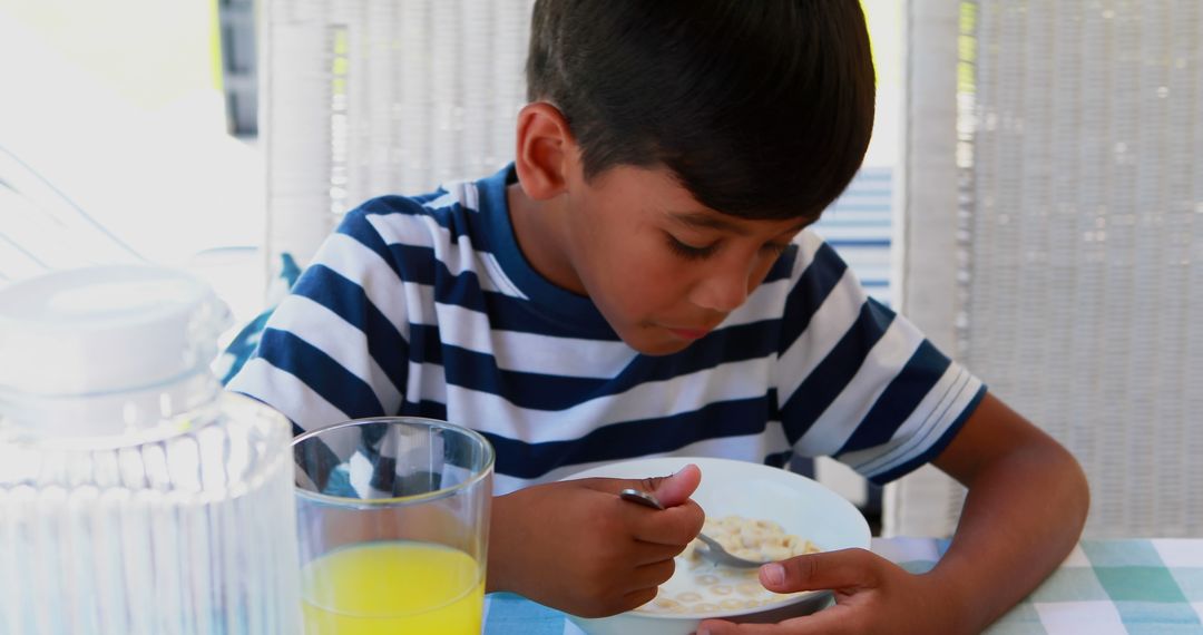 Young Boy Eating Breakfast with Juice and Cereal - Free Images, Stock Photos and Pictures on Pikwizard.com