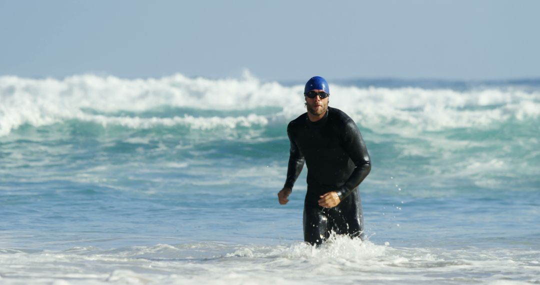 Male Surfer Wearing Wetsuit Stands in Ocean Waves - Free Images, Stock Photos and Pictures on Pikwizard.com