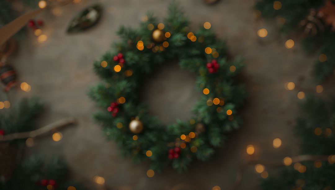 Rustic Christmas Wreath with Evergreen Sprigs, Red Berries and Warm Bokeh Lights
