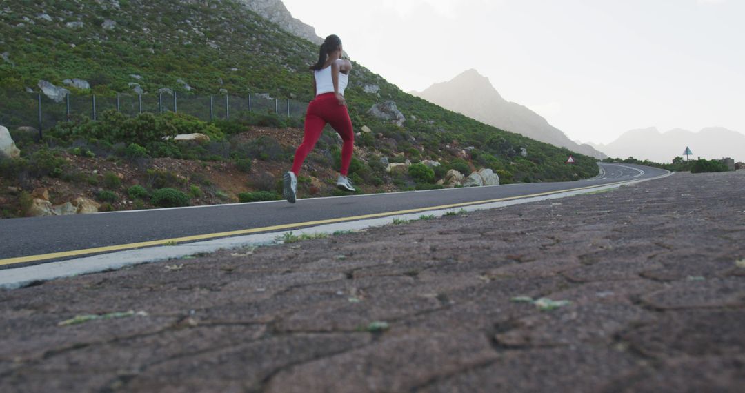 Young Woman Running on Mountain Road During Misty Morning - Free Images, Stock Photos and Pictures on Pikwizard.com