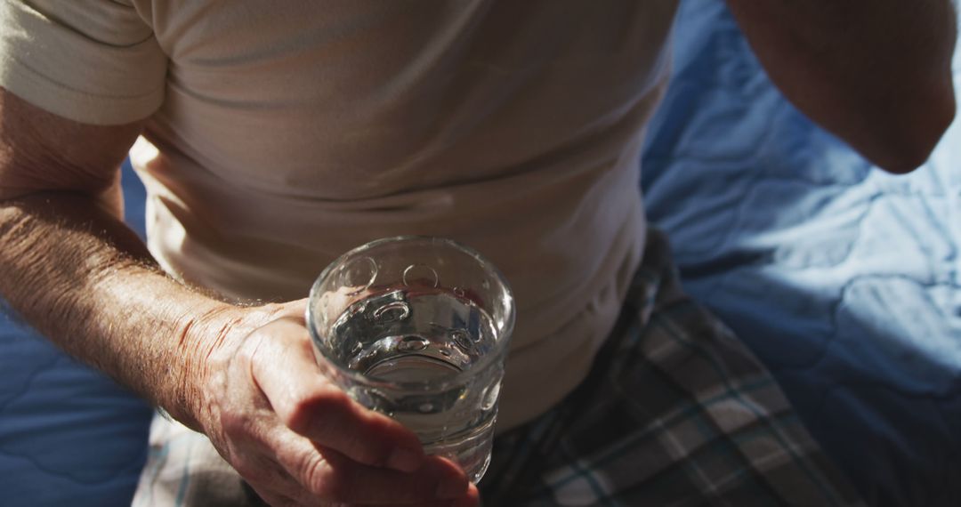 Senior Man Holding Glass of Water in Morning Light - Free Images, Stock Photos and Pictures on Pikwizard.com