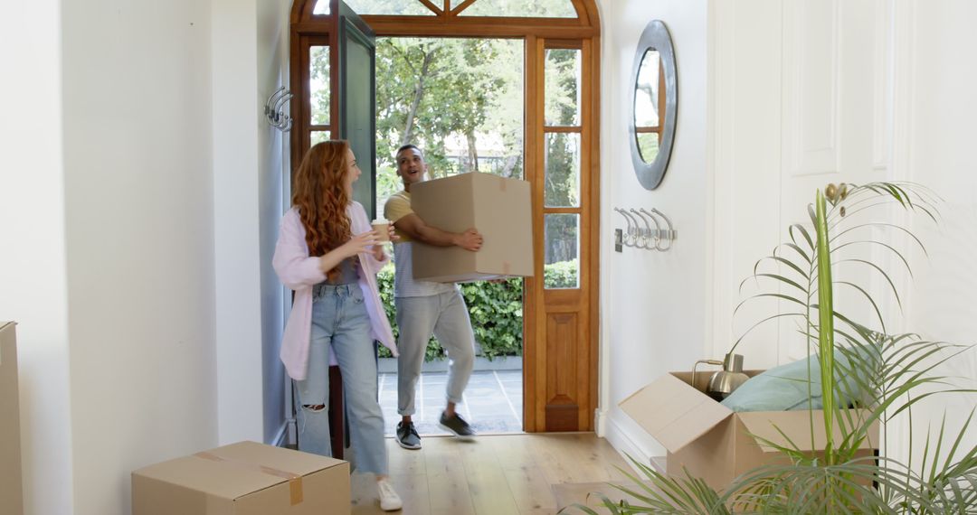 Couple Enthusiastically Moving into New Home with Cardboard Boxes
