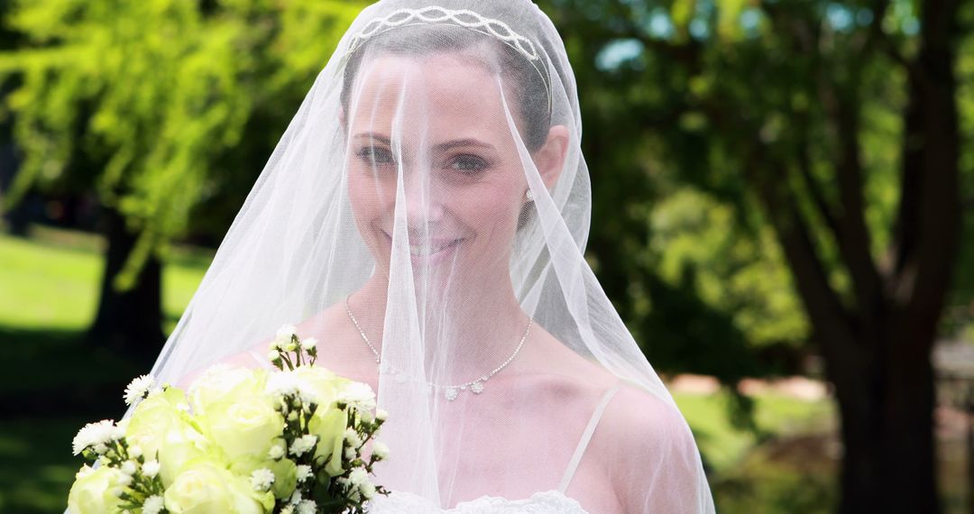 Beautiful Bride Smiling Through Veil Holding Bouquet on Sunny Wedding Day - Free Images, Stock Photos and Pictures on Pikwizard.com