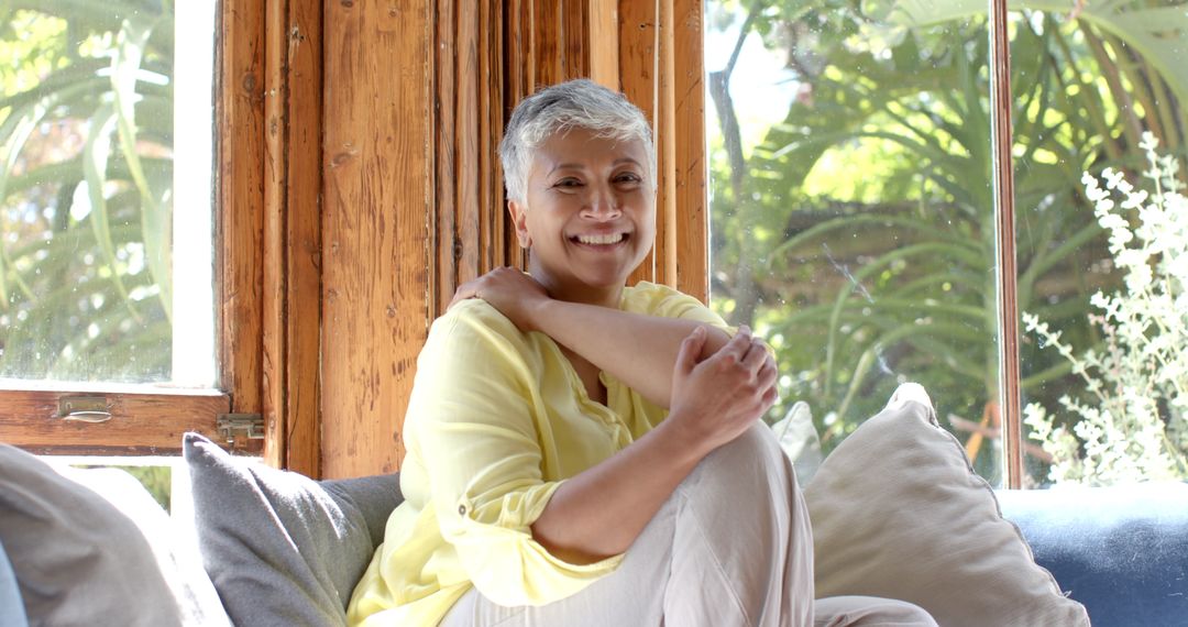 Smiling Senior Woman Relaxing on Couch in Sunny Home