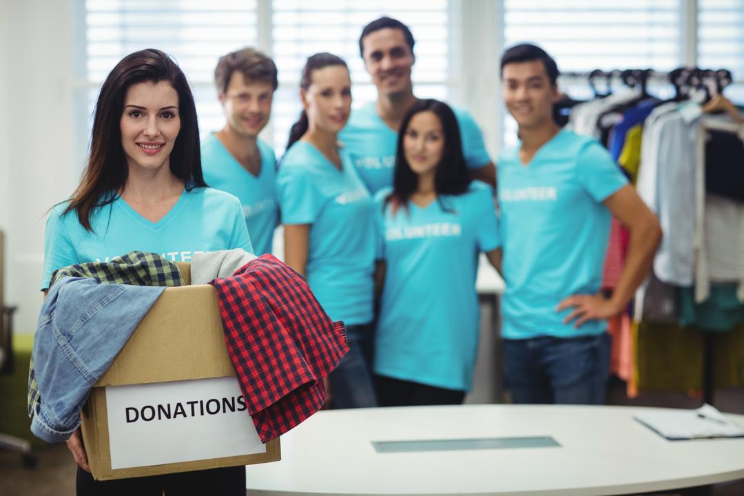 Female volunteer holding clothes in donation box - Free Images, Stock Photos and Pictures on Pikwizard.com