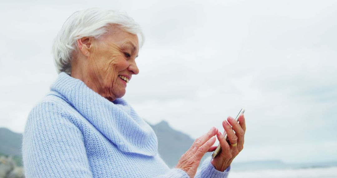 Elderly Woman Enjoying Smartphone Outdoors - Free Images, Stock Photos and Pictures on Pikwizard.com