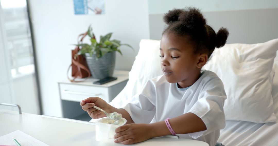 Young African American Girl Eating Yogurt in Hospital Bed - Free Images, Stock Photos and Pictures on Pikwizard.com