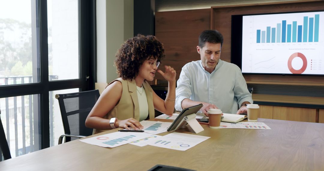 Coworkers Collaborating with Charts and Tablet at Modern Office