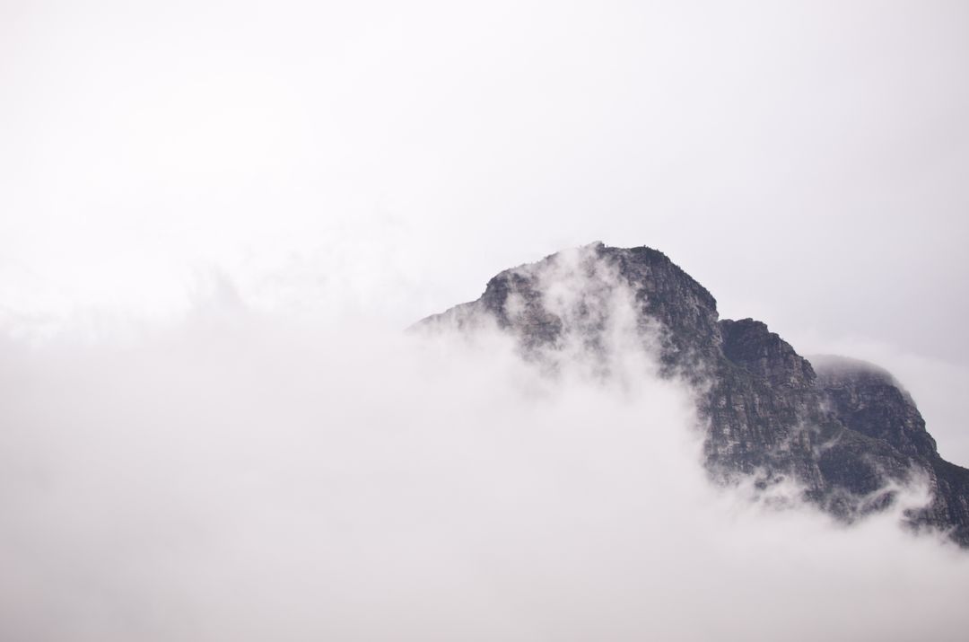 Misty Mountain Peak Surrounded by Clouds on Overcast Day - Free Images, Stock Photos and Pictures on Pikwizard.com