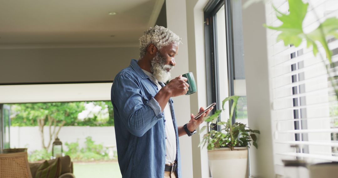 Image of african american senior man drinking coffee and using tablet - Free Images, Stock Photos and Pictures on Pikwizard.com