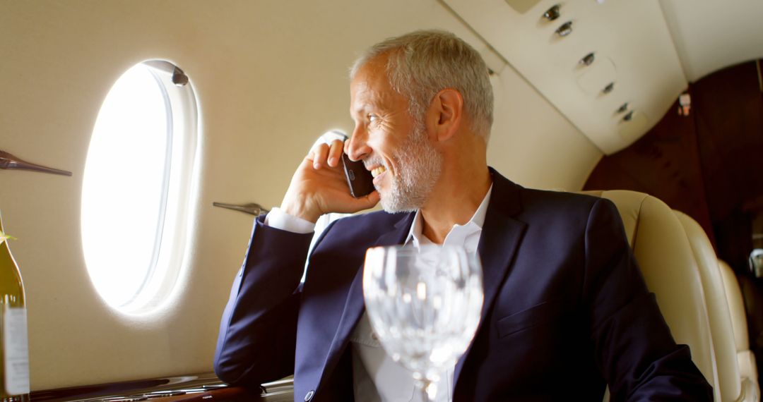 Businessman Talking on Phone in Private Jet, Smiling and Relaxed - Free Images, Stock Photos and Pictures on Pikwizard.com