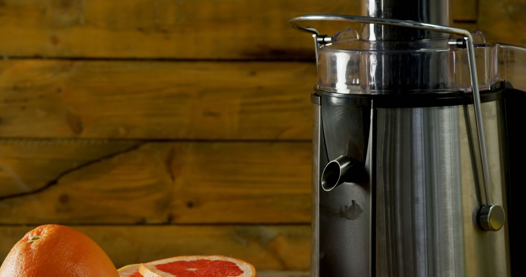 Stainless Steel Juicer with Fresh Grapefruits on Wooden Table - Free Images, Stock Photos and Pictures on Pikwizard.com