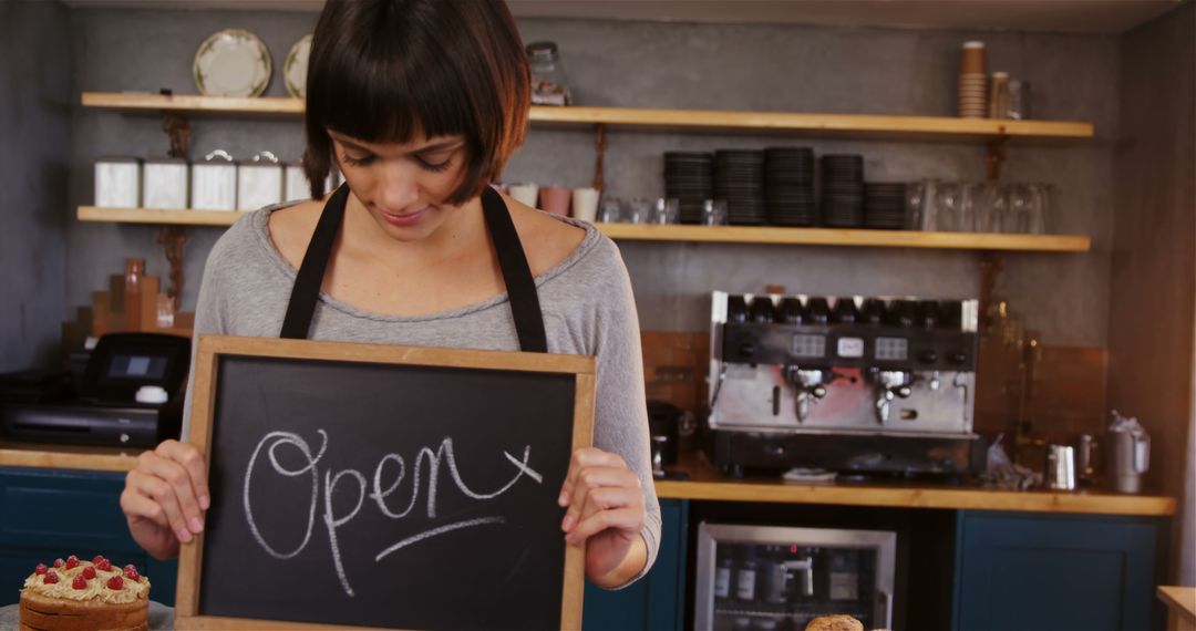 Friendly Female Barista Holding Open Sign in Cozy Cafe - Free Images, Stock Photos and Pictures on Pikwizard.com