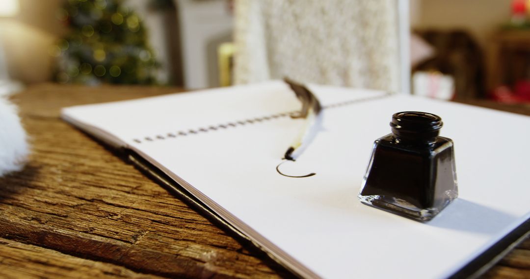 An open notebook with a quill pen and an ink bottle is placed on a wooden surface, with copy space - Free Images, Stock Photos and Pictures on Pikwizard.com