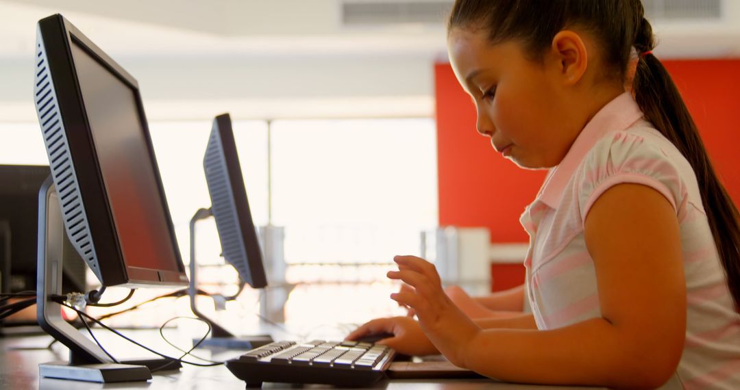 Young Schoolgirl Typing on Classroom Computer