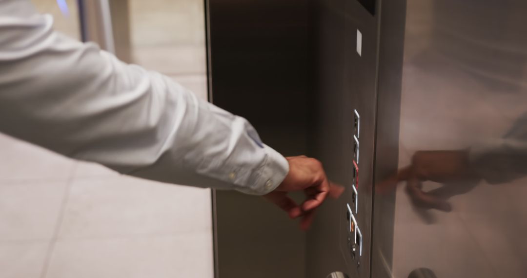 Person Pressing Button on Modern Elevator Control Panel