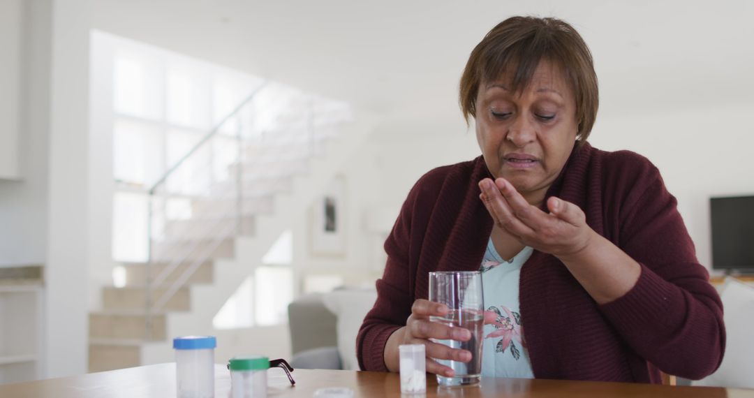 Senior woman taking medication with water at home - Free Images, Stock Photos and Pictures on Pikwizard.com