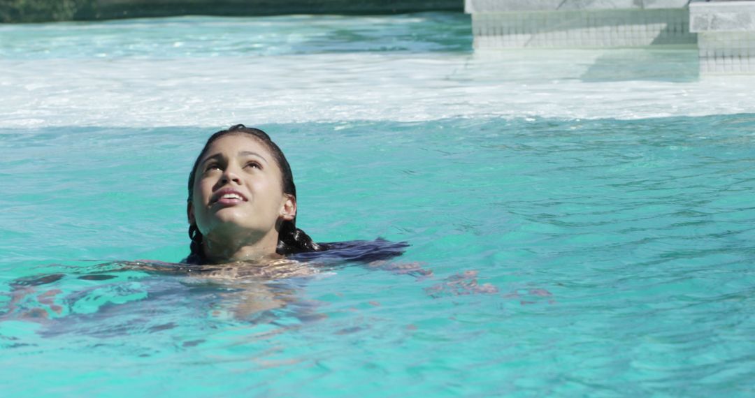 Relaxed Woman Enjoying Refreshing Swim in Pristine Pool Setting